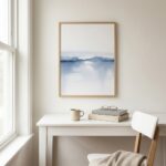 Minimalist watercolor painting featuring soft blue lake with misty mountains and white sky in wooden frame